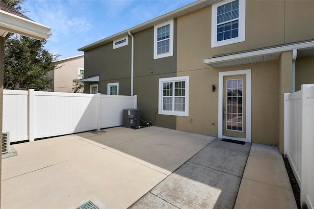 rear view of house with central AC and a patio area