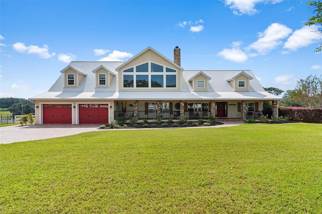 view of front of property featuring covered porch, a garage, and a front yard