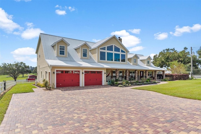 view of front facade with a porch, a front yard, and a garage