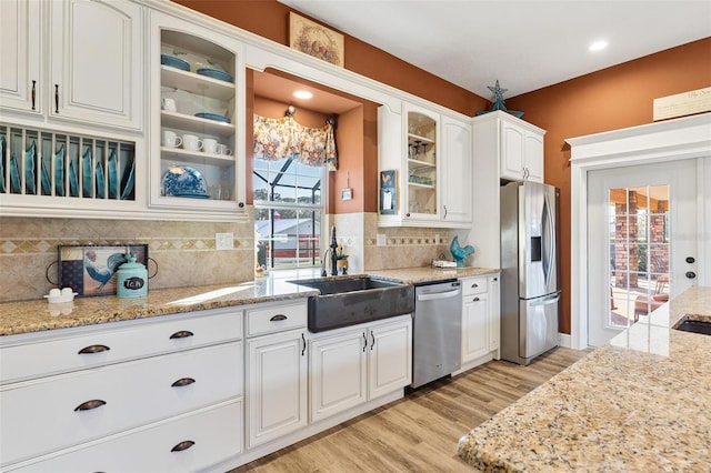 kitchen featuring appliances with stainless steel finishes, white cabinets, tasteful backsplash, and plenty of natural light