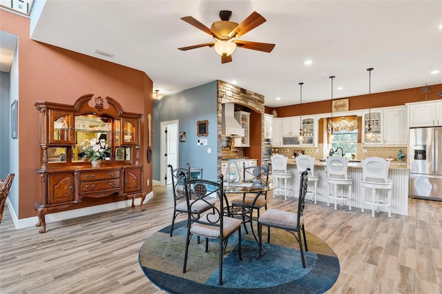 dining space with light hardwood / wood-style flooring and ceiling fan