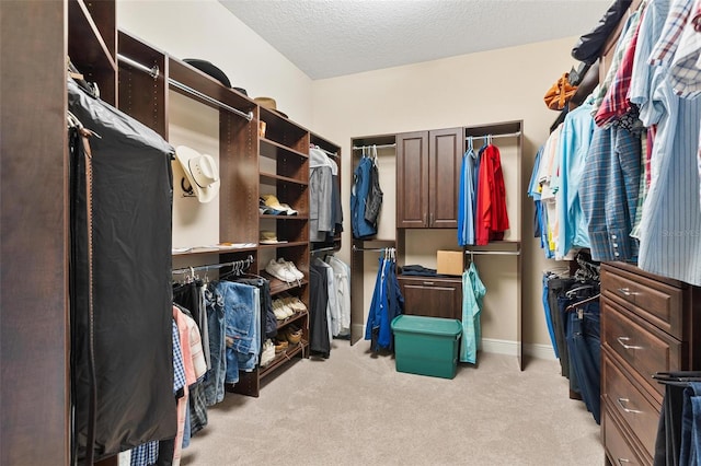 walk in closet featuring light carpet