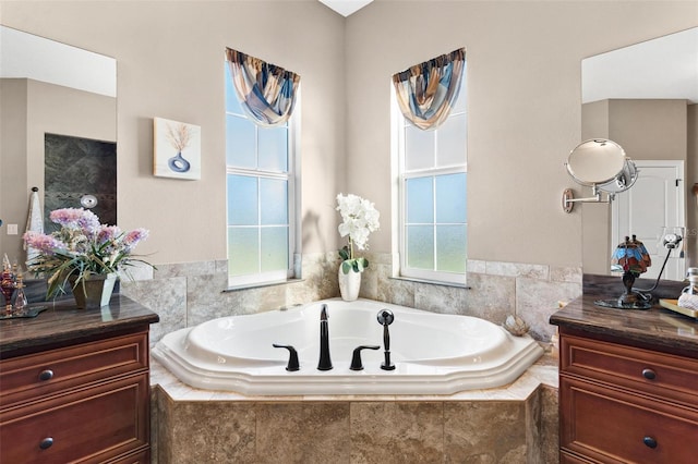 bathroom with vanity and tiled tub