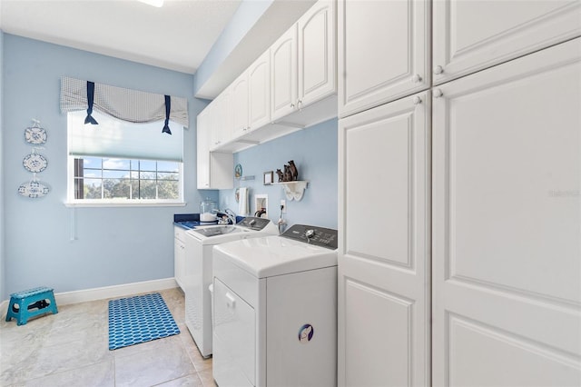 laundry room with cabinets, washer and dryer, and light tile patterned flooring