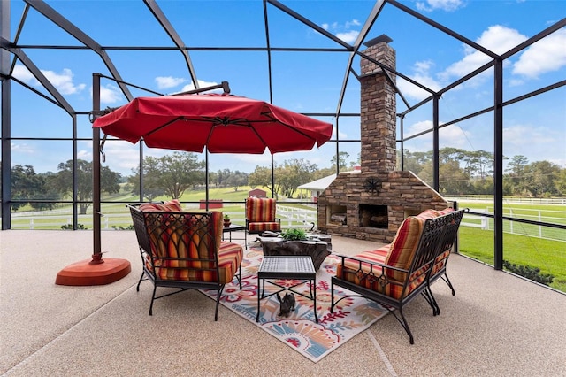 view of patio with a lanai and an outdoor stone fireplace