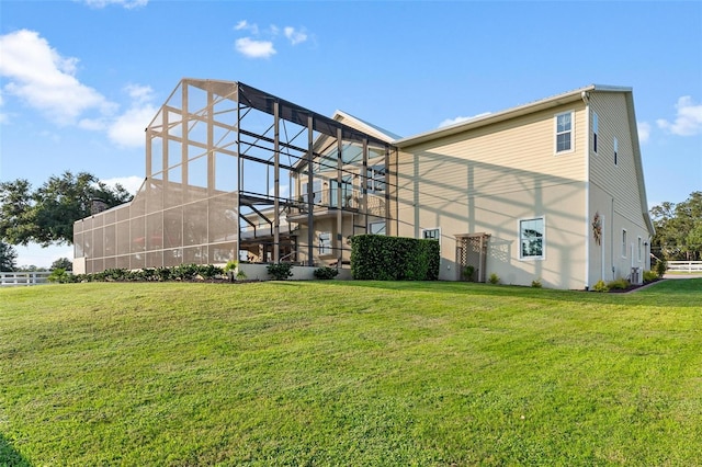 back of house with a lawn and a lanai