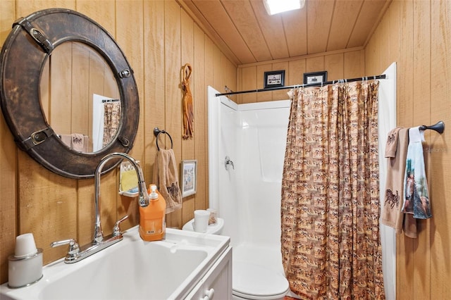 bathroom with vanity, a shower with curtain, toilet, and wood walls