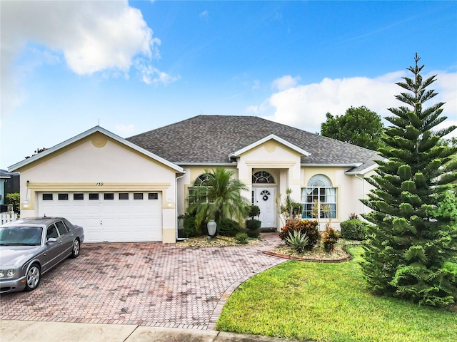 ranch-style house featuring a front yard and a garage