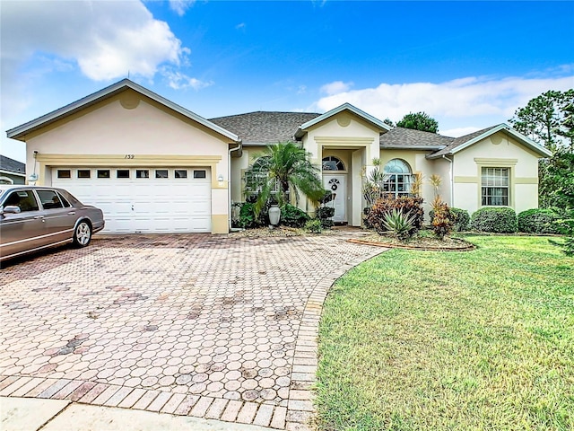 139 Belfry Dr, Davenport, FL 33897 - ranch-style home with stucco siding, a front yard, decorative driveway, an attached garage, and roof with shingles