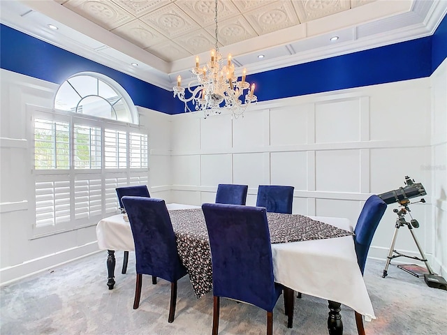 dining space featuring a notable chandelier, a tray ceiling, and ornamental molding