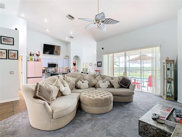 tiled living room with high vaulted ceiling and ceiling fan