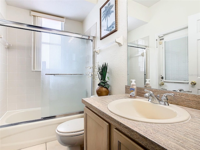 full bathroom featuring shower / bath combination with glass door, toilet, vanity, and tile patterned floors