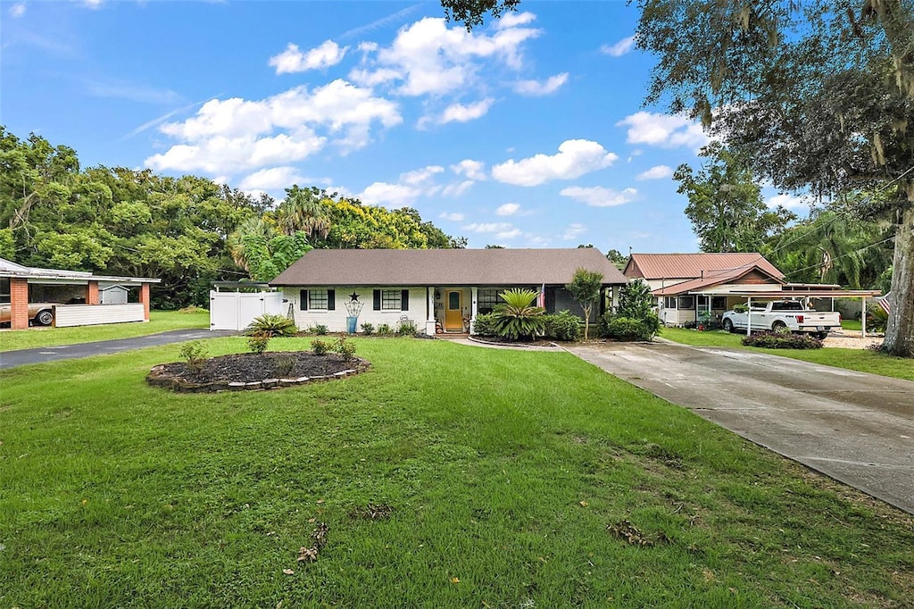 ranch-style house featuring a front lawn and a carport