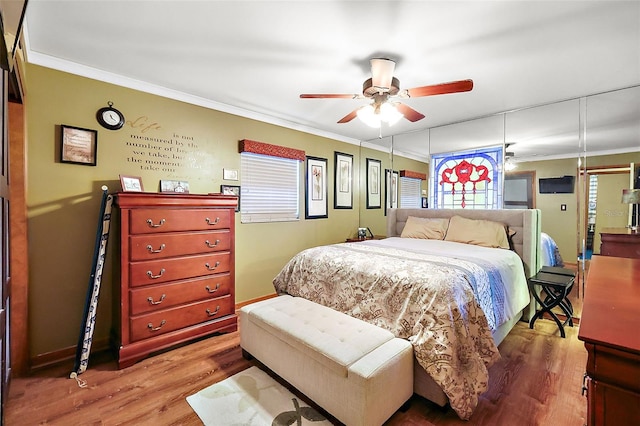 bedroom with ceiling fan, crown molding, and wood-type flooring