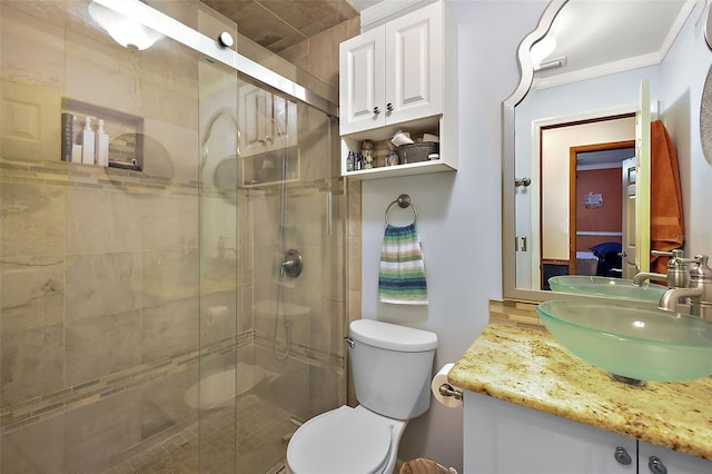 bathroom with an enclosed shower, vanity, and toilet