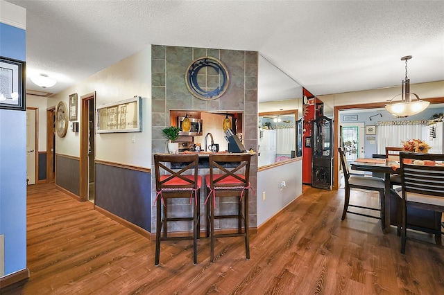 kitchen with pendant lighting, a textured ceiling, and dark hardwood / wood-style flooring