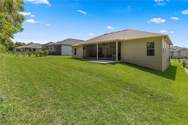 rear view of house featuring a lawn, a lanai, and a patio