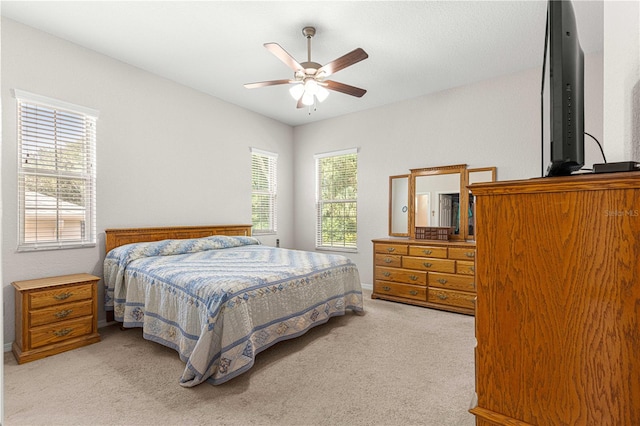 bedroom featuring light carpet and ceiling fan