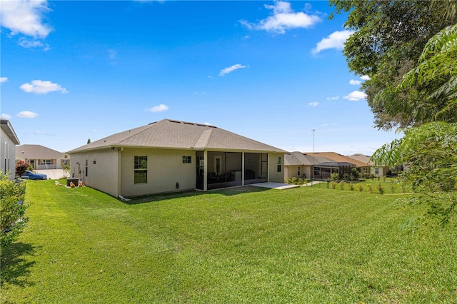 back of property featuring a sunroom, a yard, and a patio area