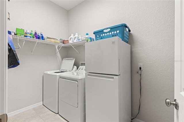 laundry area with washing machine and dryer and light tile patterned flooring