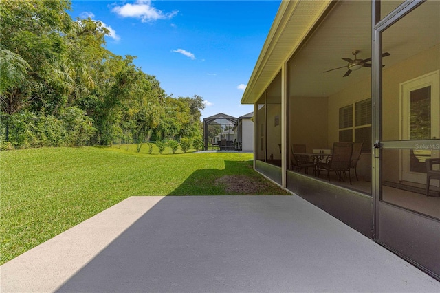 view of yard featuring a lanai, a patio, and ceiling fan