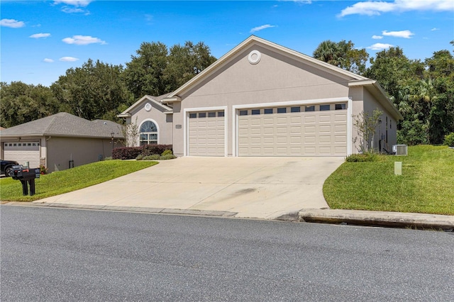 view of front of home with central AC unit, a garage, and a front yard