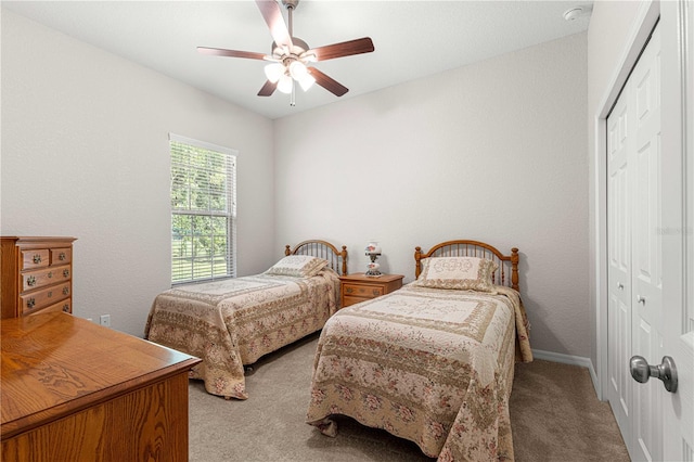 bedroom with ceiling fan, light colored carpet, and a closet