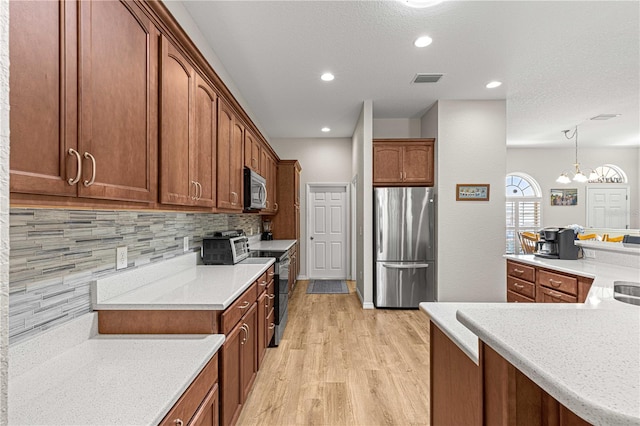 kitchen with pendant lighting, light wood-type flooring, a chandelier, tasteful backsplash, and appliances with stainless steel finishes