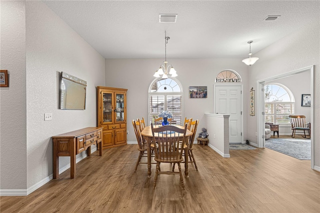 dining area featuring an inviting chandelier, light hardwood / wood-style floors, and a wealth of natural light