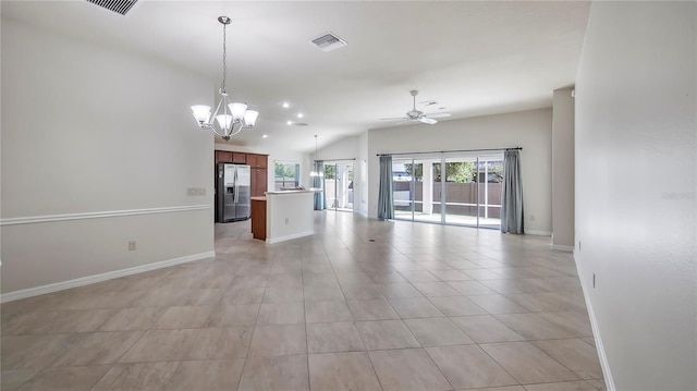 unfurnished living room with ceiling fan with notable chandelier, lofted ceiling, and light tile patterned flooring