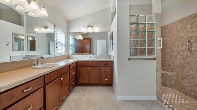 bathroom featuring vaulted ceiling, vanity, tile patterned flooring, and a tile shower