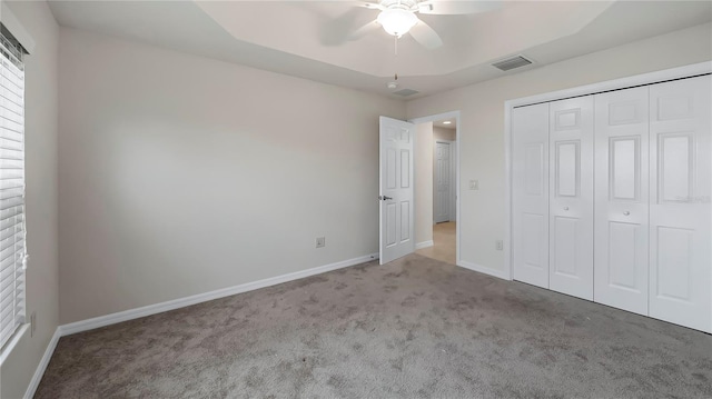 unfurnished bedroom with ceiling fan, a closet, and light carpet