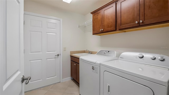 laundry room with cabinets, sink, independent washer and dryer, and light tile patterned flooring