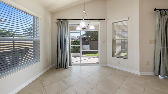 interior space featuring a notable chandelier, vaulted ceiling, plenty of natural light, and light tile patterned flooring