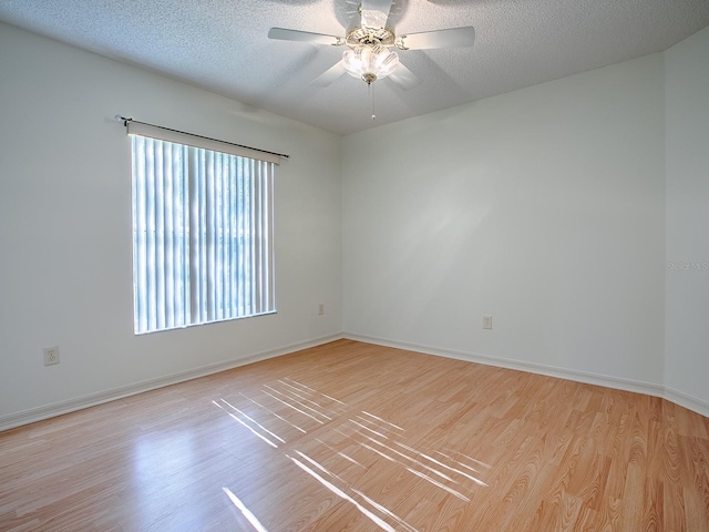 empty room with a textured ceiling, light hardwood / wood-style floors, and a healthy amount of sunlight