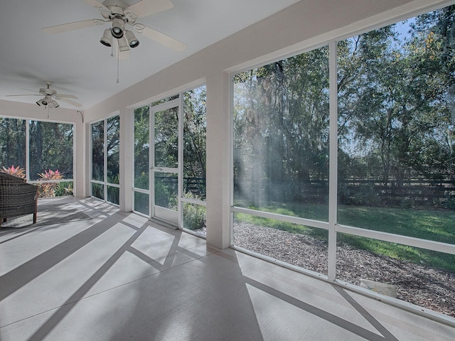 unfurnished sunroom with ceiling fan