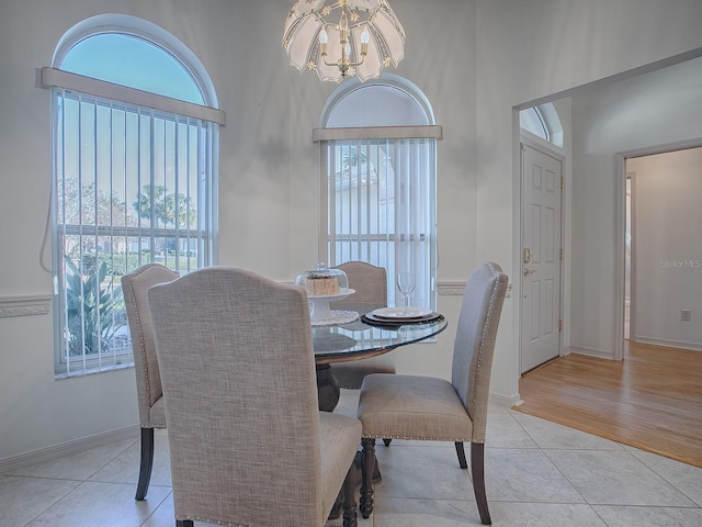 tiled dining area featuring an inviting chandelier