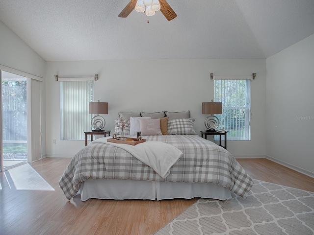 bedroom featuring access to exterior, light hardwood / wood-style flooring, ceiling fan, and lofted ceiling