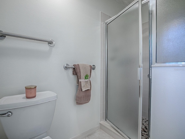 bathroom with a shower with door and toilet