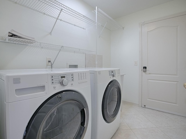 laundry room with washing machine and dryer and light tile patterned floors