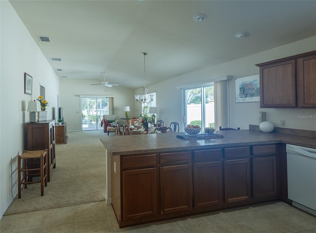 kitchen with a healthy amount of sunlight, lofted ceiling, dishwasher, and light colored carpet