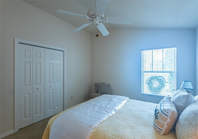 bedroom with a closet, carpet flooring, vaulted ceiling, and ceiling fan