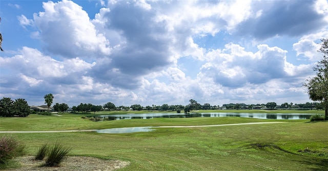 view of home's community with a water view and a yard