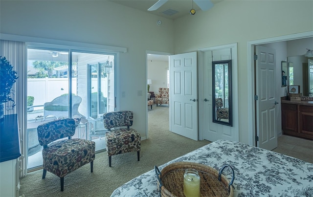 bedroom featuring ceiling fan, ensuite bathroom, light colored carpet, and access to exterior