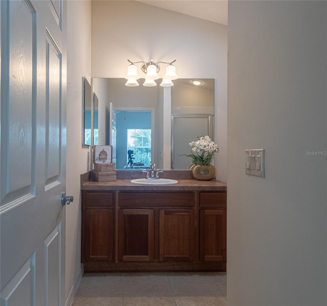 bathroom with vanity, vaulted ceiling, and tile patterned flooring