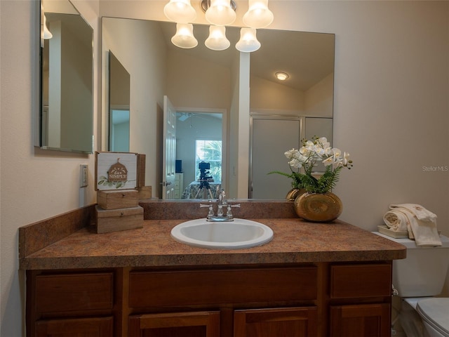 bathroom featuring vanity, toilet, walk in shower, and vaulted ceiling