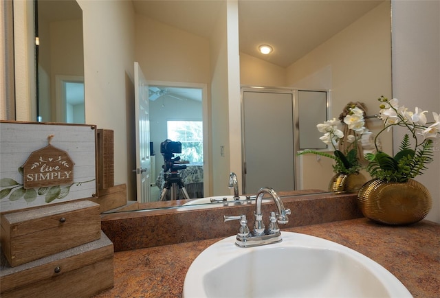 bathroom with vanity, ceiling fan, walk in shower, and lofted ceiling