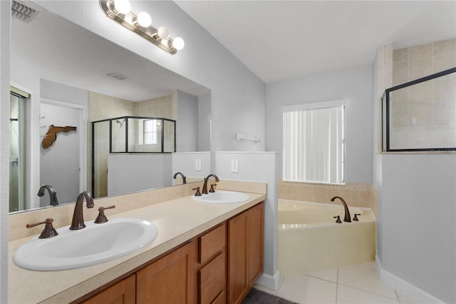 bathroom with tile patterned flooring, shower with separate bathtub, a textured ceiling, and vanity