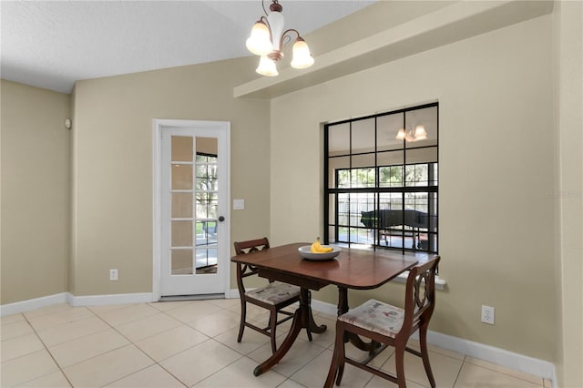 tiled dining space featuring plenty of natural light, a textured ceiling, and an inviting chandelier