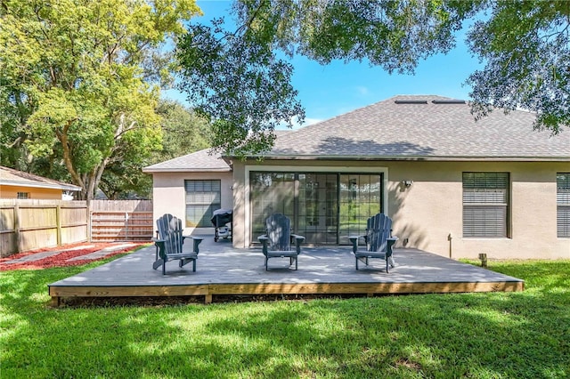 rear view of house with a deck and a lawn